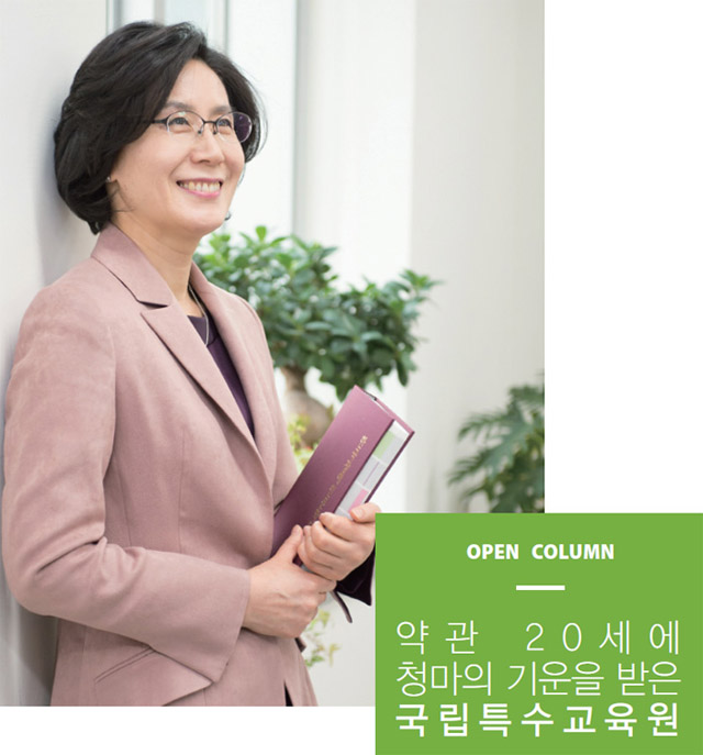 책을 들고 서서 벽에 기대어 있는 김은주 원장