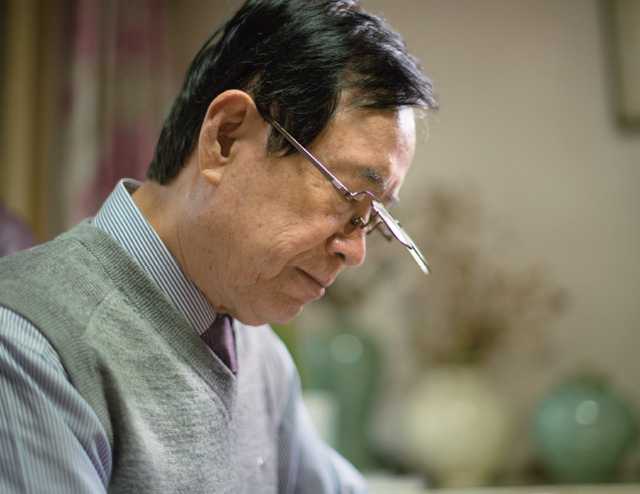 고개 숙여 책을 보고 있는 김영환 전 원장 모습