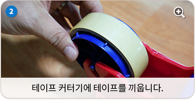 테이프커터기에 테이프를 끼웁니다.