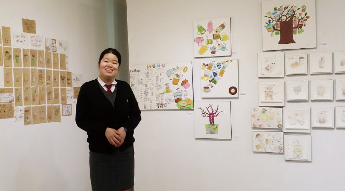 비주가 미술 작품을 배경으로 서있는 사진