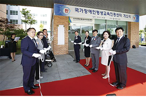 국가장애인평생교육진흥센터 개소식 때 김상곤 부총리 겸 교육부장관, 윤여각 국가평생교육진흥원장, 장애인 관련 기관 및 단체 관계자가 컷팅식을 하는 장면